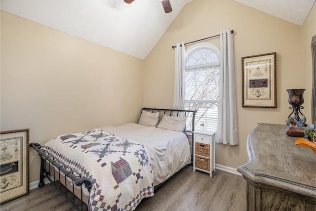 bedroom with lofted ceiling, baseboards, and dark wood-style flooring