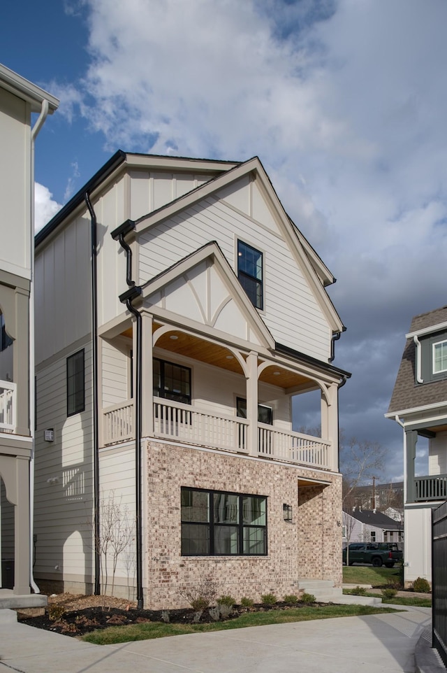 view of front of house featuring brick siding and a balcony