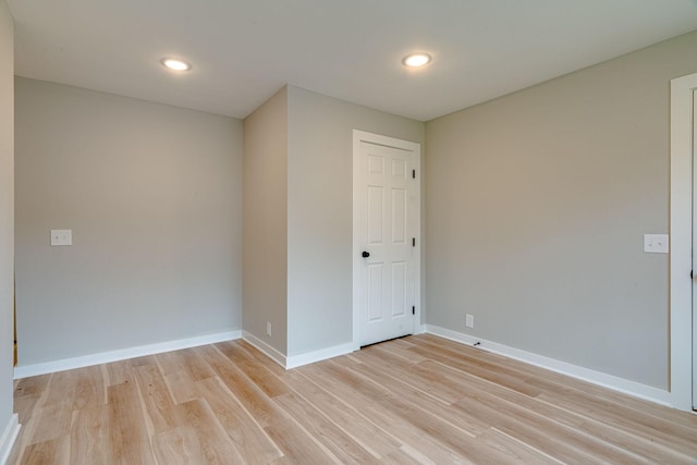 empty room featuring light wood-type flooring and baseboards