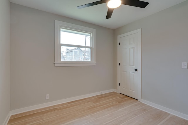 empty room with baseboards, ceiling fan, and light wood finished floors