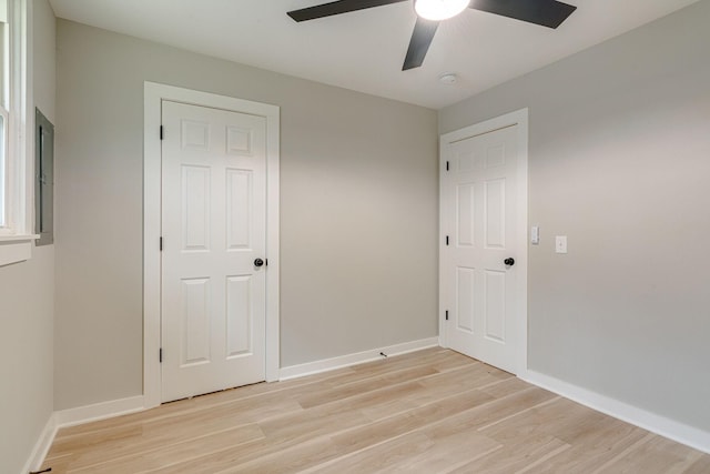 empty room featuring baseboards, ceiling fan, and light wood-style floors