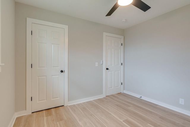 unfurnished bedroom with light wood-style floors, baseboards, and a ceiling fan