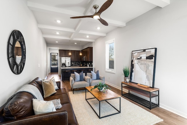 living area featuring light wood-type flooring, beam ceiling, baseboards, and recessed lighting