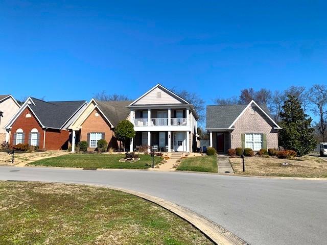 view of front of property featuring a front yard and a balcony