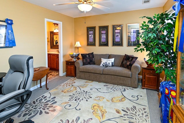 carpeted living room with baseboards, visible vents, and a ceiling fan