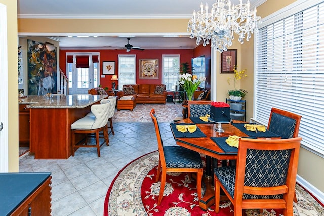 dining room with light tile patterned floors, baseboards, ornamental molding, and ceiling fan with notable chandelier