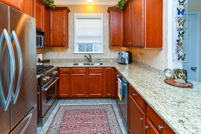 kitchen with appliances with stainless steel finishes, crown molding, a sink, and light stone countertops