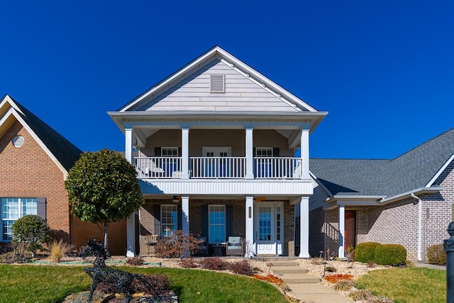 neoclassical / greek revival house with a balcony, a porch, and brick siding