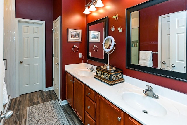 bathroom with double vanity, wood finish floors, and a sink