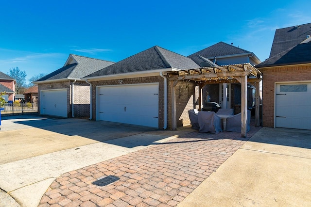 view of front facade featuring roof with shingles, brick siding, concrete driveway, a pergola, and a garage