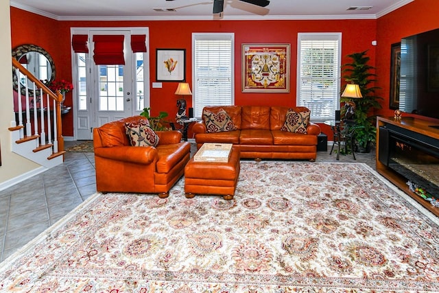 living area featuring visible vents, a ceiling fan, tile patterned floors, stairs, and crown molding