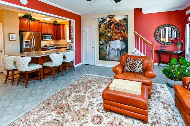 interior space with light stone counters, appliances with stainless steel finishes, decorative backsplash, a kitchen bar, and crown molding