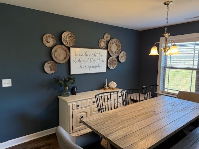 dining room featuring visible vents, baseboards, dark wood-type flooring, and a notable chandelier