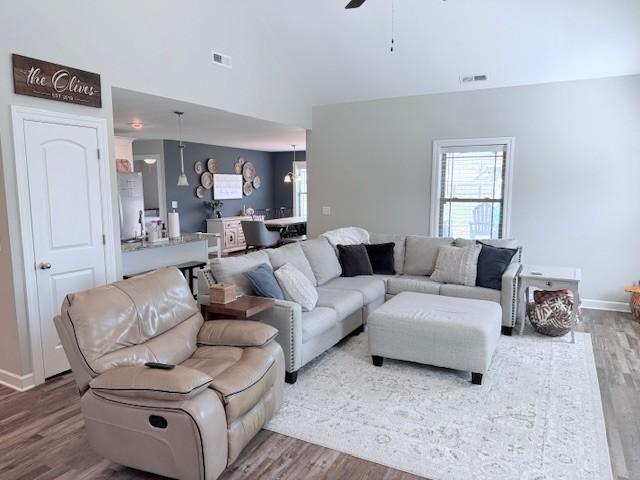 living room with plenty of natural light, visible vents, and wood finished floors