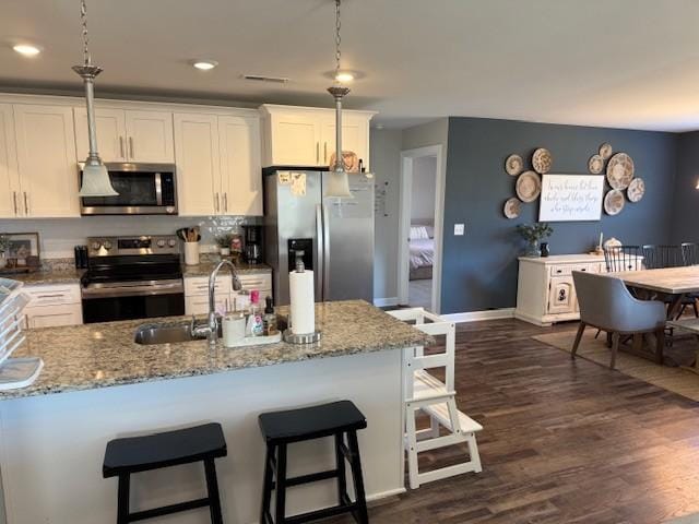 kitchen with stainless steel appliances, dark wood finished floors, and white cabinets