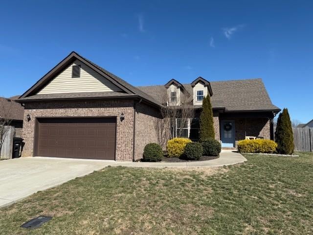 view of front of home featuring brick siding, a front yard, fence, a garage, and driveway