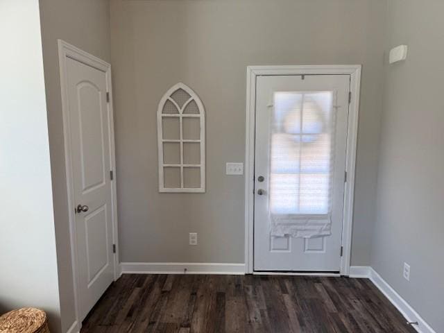 doorway to outside with dark wood finished floors and baseboards