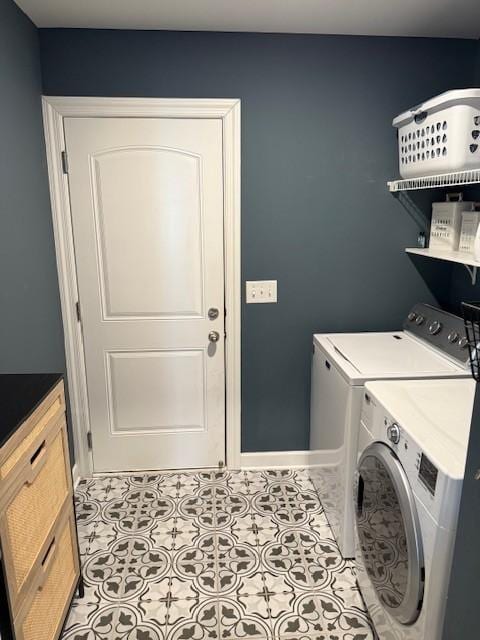 washroom featuring light tile patterned floors, laundry area, separate washer and dryer, and baseboards