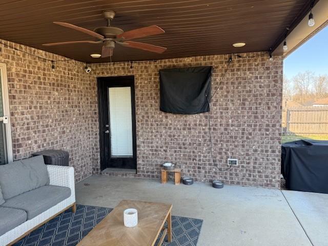 view of patio featuring a grill, fence, and ceiling fan