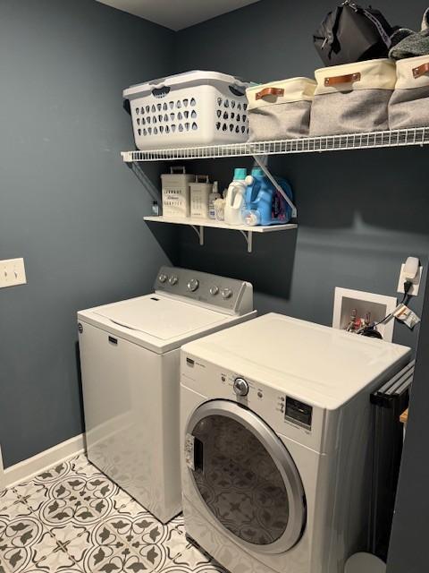 washroom featuring laundry area, independent washer and dryer, baseboards, and light tile patterned floors