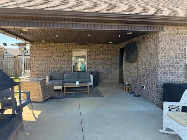 view of patio / terrace featuring an attached carport, fence, and an outdoor hangout area