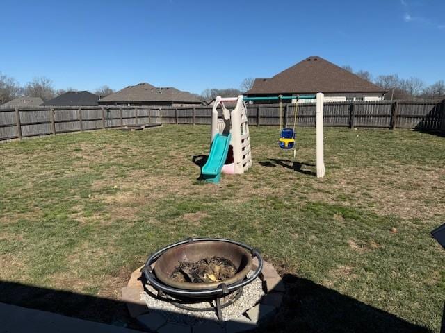 view of yard featuring a fenced backyard and a fire pit