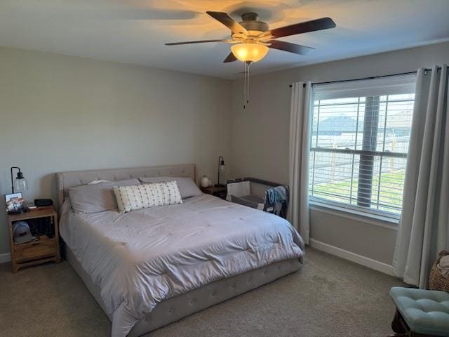 bedroom featuring light carpet, baseboards, and a ceiling fan