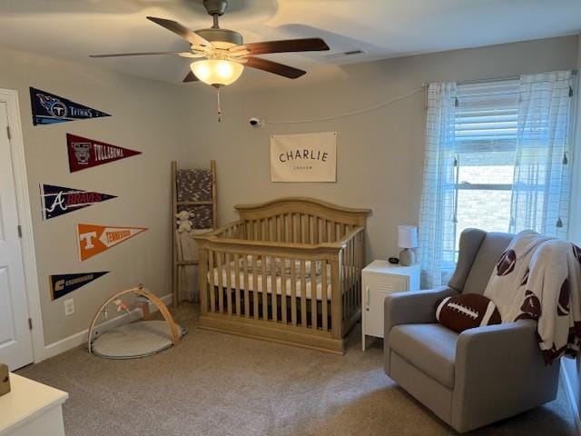 carpeted bedroom with a nursery area, ceiling fan, visible vents, and baseboards