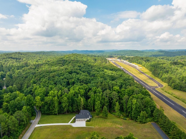 bird's eye view with a wooded view