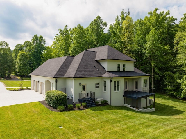 back of property featuring a garage, a yard, cooling unit, and driveway