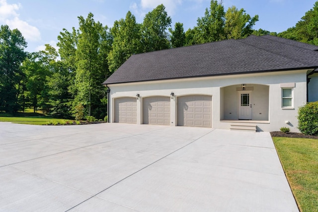 view of front of home with a shingled roof, driveway, and stucco siding