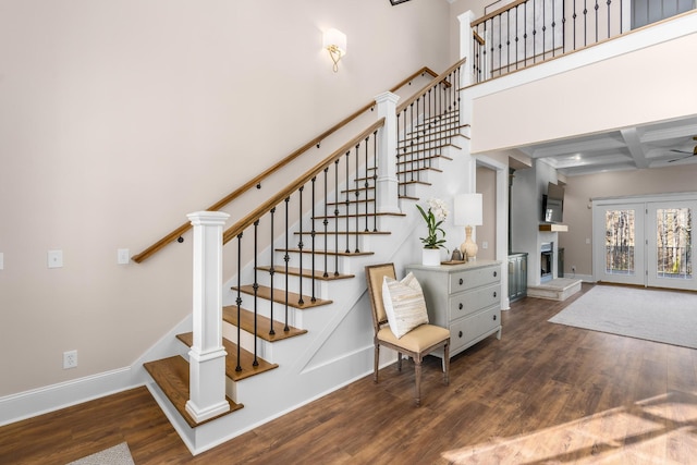 stairs featuring beam ceiling, coffered ceiling, baseboards, and wood finished floors