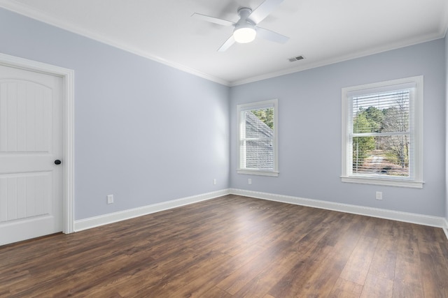 empty room with dark wood finished floors, visible vents, ornamental molding, ceiling fan, and baseboards