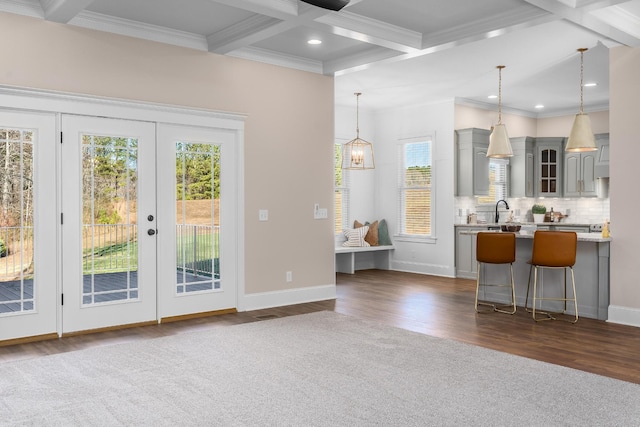 doorway with dark wood-style floors, coffered ceiling, beamed ceiling, and crown molding