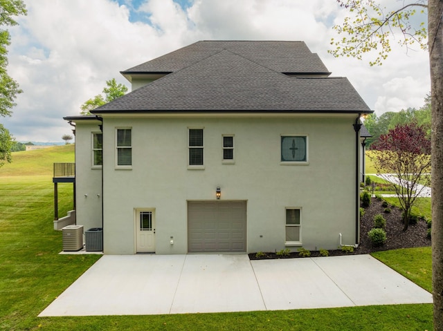 back of property featuring driveway, a shingled roof, a lawn, and cooling unit