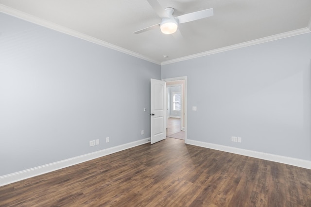 spare room featuring dark wood-style floors, crown molding, baseboards, and ceiling fan