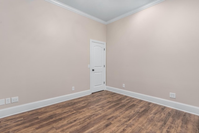 spare room featuring baseboards, ornamental molding, and dark wood finished floors