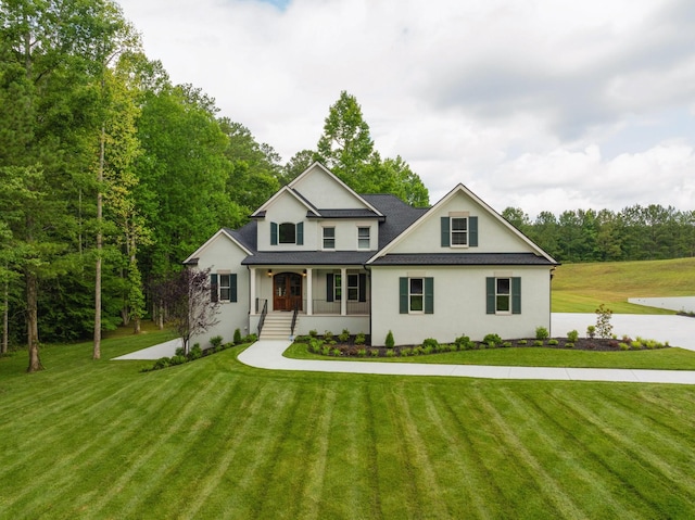 view of front of home with a porch, a front lawn, and a shingled roof