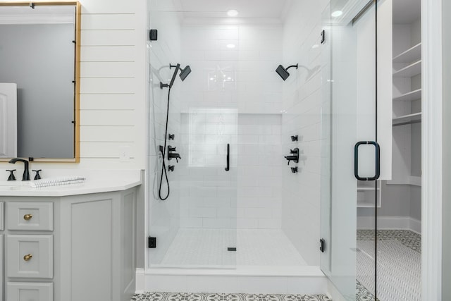 full bathroom featuring ornamental molding, a shower stall, and vanity