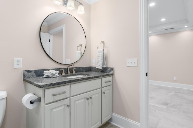 bathroom with baseboards, ornamental molding, and vanity