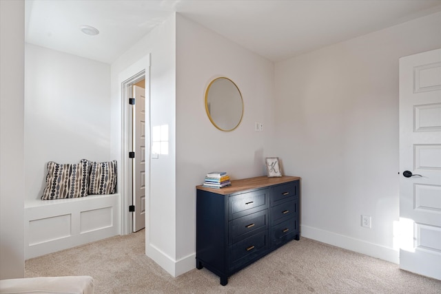 hall with light colored carpet and baseboards