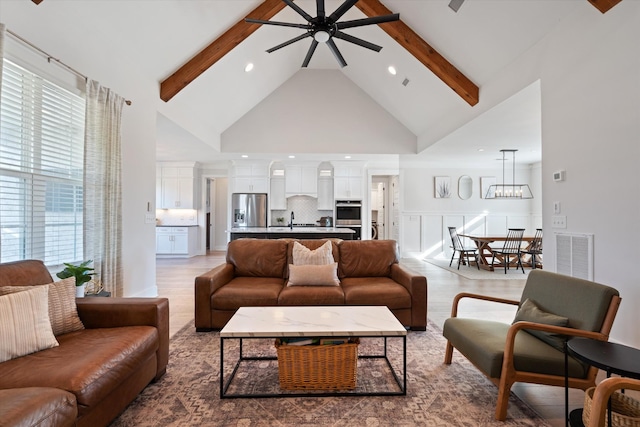 living area featuring high vaulted ceiling, visible vents, beamed ceiling, and wood finished floors