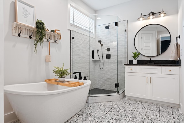 bathroom featuring a freestanding tub, a shower stall, vanity, and tile patterned floors