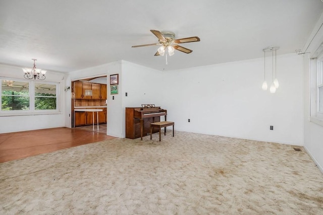 living room featuring carpet flooring and ceiling fan with notable chandelier