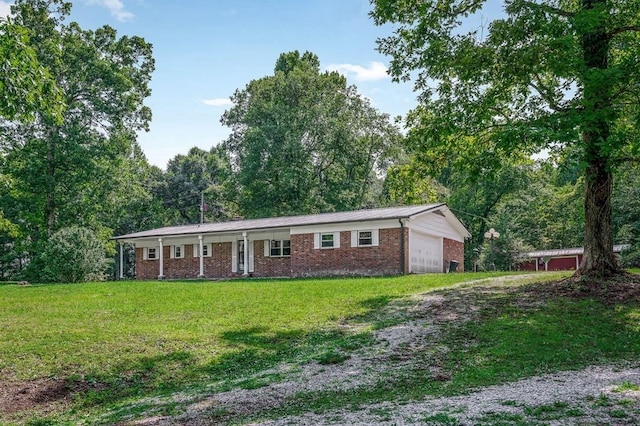 single story home with brick siding, an attached garage, and a front yard