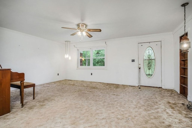 interior space with carpet floors, crown molding, and a ceiling fan