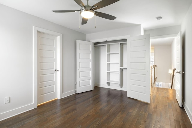 unfurnished bedroom with a closet, dark wood finished floors, and baseboards