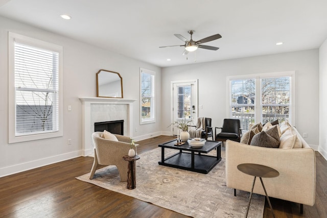 living room with ceiling fan, recessed lighting, dark wood-type flooring, a fireplace, and baseboards