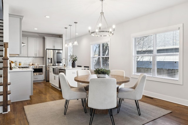 dining area with dark wood finished floors, a notable chandelier, recessed lighting, visible vents, and baseboards