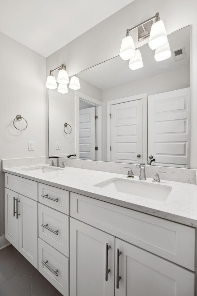 bathroom featuring tile patterned flooring, a sink, and double vanity